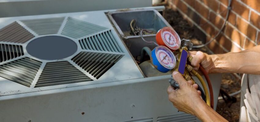 A skilled man fixes some parts of an ac unit.