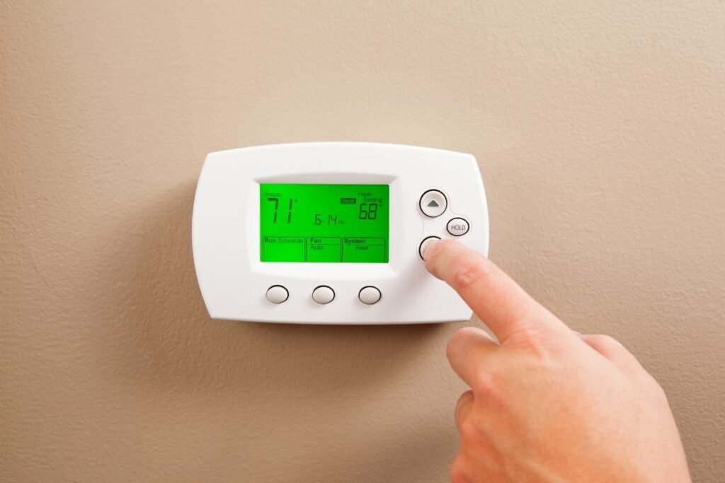 The person checks the thermostat in the HVAC system.