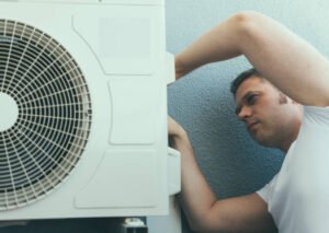 A technician performs AC repair in Margate, FL, using tools to fix an air conditioner’s internal components with precision and care.