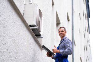 A professional HVAC contractor in Sunrise, FL, offering expert HVAC services, stands in a casual setting, wearing a blue shirt and overalls, holding a file.