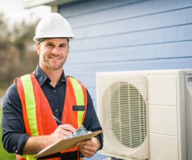 A man wearing a hard hat and safety vest holds a clipboard, representing HVAC contractors in Sunrise FL at a construction site