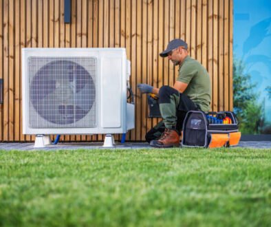 A man repairs an air conditioner, focused on the unit with tools in hand, in a well-lit indoor environment – AC repair service near me in Coconut Creek, FL.