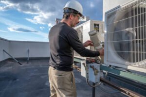 HVAC technician repairs an air conditioner, focused on the unit with tools in hand, wearing safety gloves and a work uniform, ensuring the right HVAC system works efficiently for a South Florida home.