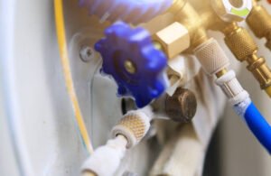 Close-up of an air conditioner drain line with hose connected, highlighting condensate drainage and potential leak source.
