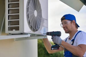 A man performs AC maintenance in Pompano Beach, using tools to service an indoor air conditioning unit.