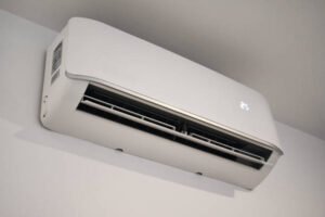 Wall-mounted white ductless mini-split air conditioner, designed for efficient temperature control in indoor spaces.