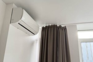 A white air conditioning unit mounted on the wall, providing cooling for the room.