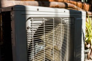 Close-up of a heat pump installed in a garden, showcasing its design and placement for replacing an AC condenser.