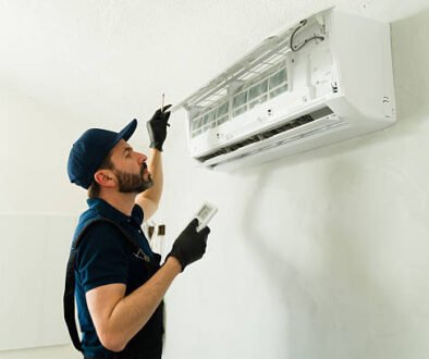 A man in blue gloves works on an air conditioner, providing essential Air Conditionere repair services.