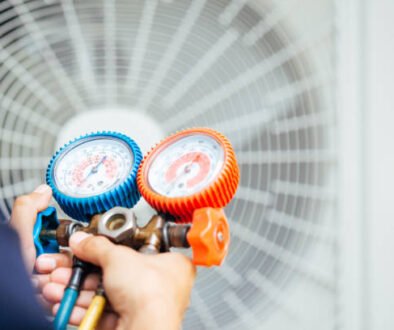A man holding two air conditioner gauges, representing Best Local Air Conditioner Repair services.