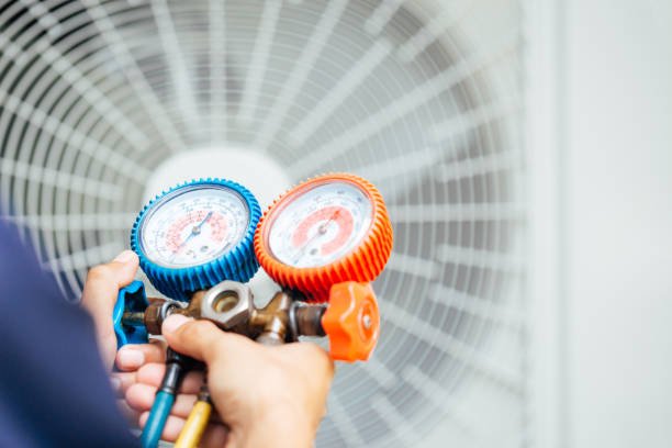 A man holding two air conditioner gauges, representing Best Local Air Conditioner Repair services.