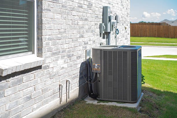 A large air conditioner positioned in front of a house, indicating professional HVAC installation.