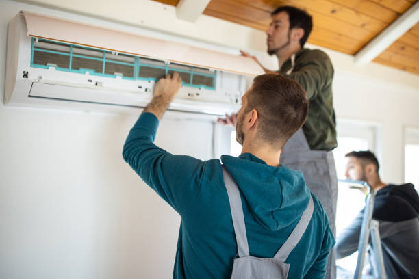 A man is engaged in air conditioner repair, using tools to troubleshoot and fix the cooling system.