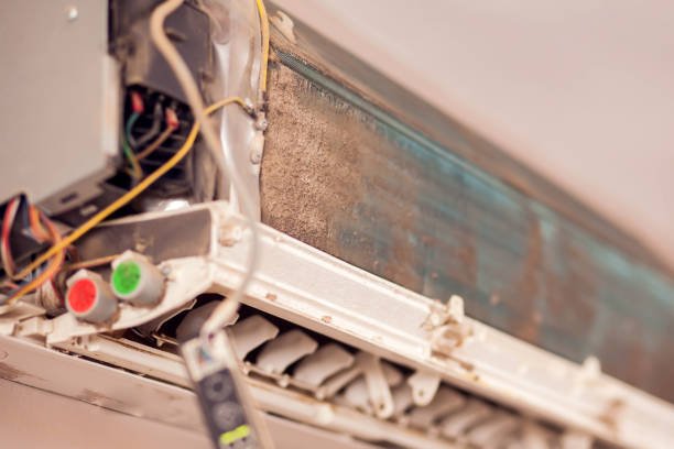 A dirty air conditioner with exposed wires, emitting a bad smell, indicating potential maintenance issues.