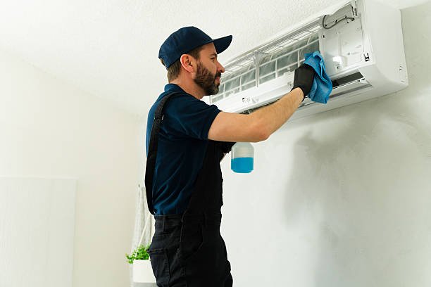 A man cleaning an air conditioner to eliminate bad odors and improve air quality.