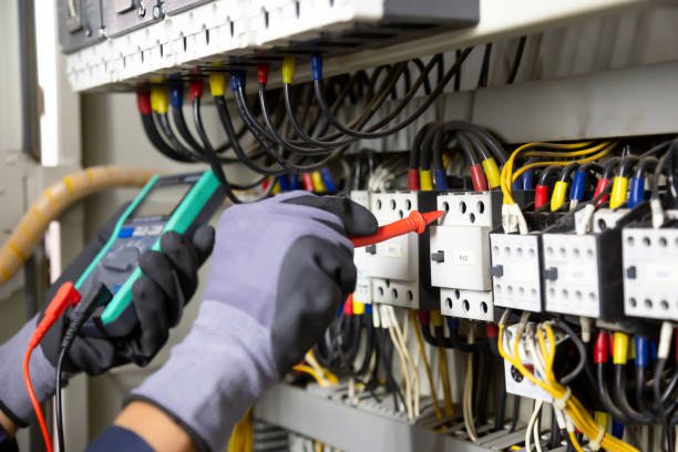 Electrical technician inspecting and working on an electrical panel in an HVAC services setting.