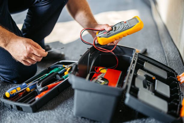 A man holds a multimeter and tools, ready to perform residential HVAC service.