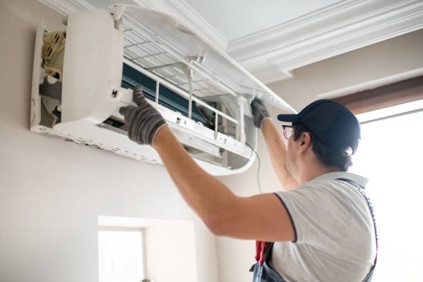 How to Choose the Best Residential AC Repair in Coral Springs, FL 1 A man, an AC repair technician, is fixing an air conditioner unit outdoors.