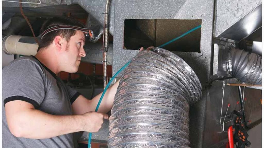 A technician is working on a home's duct system, ensuring proper HVAC functionality and air distribution.
