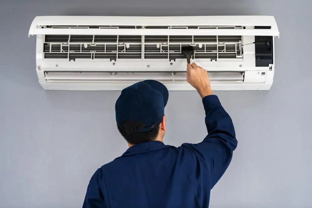 An ac repair & installation services technician is fixing indoor unit of an AC