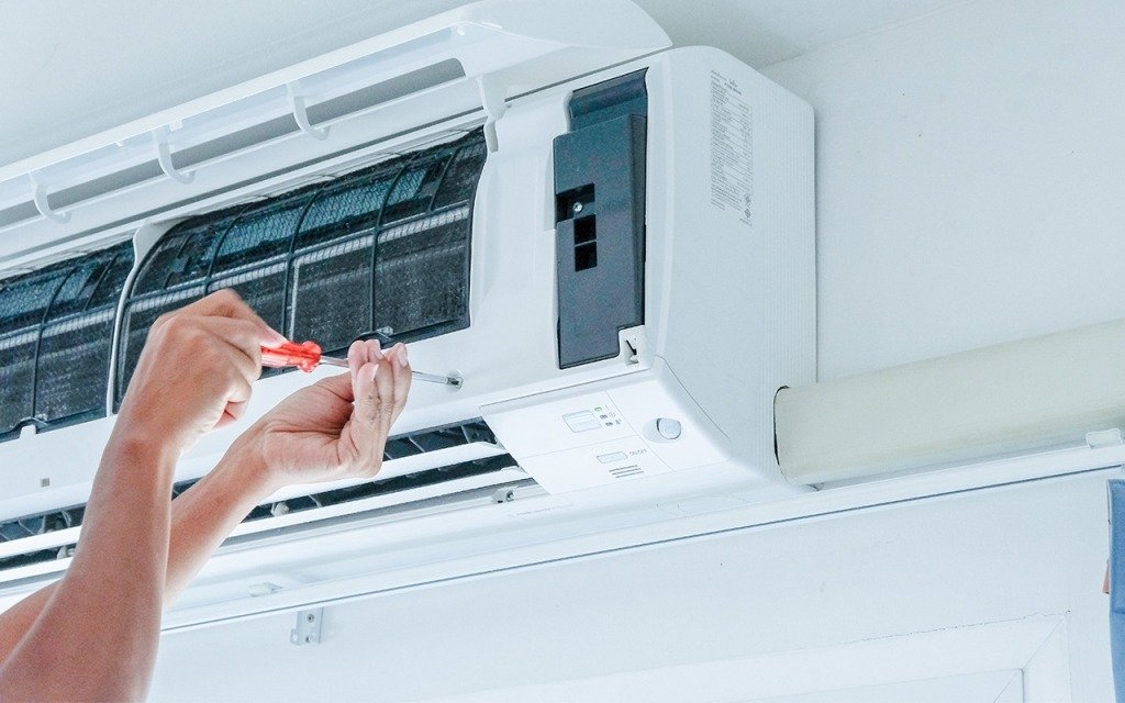 Some one is fixing an indoor unit of an ac, ac repair and installation services.